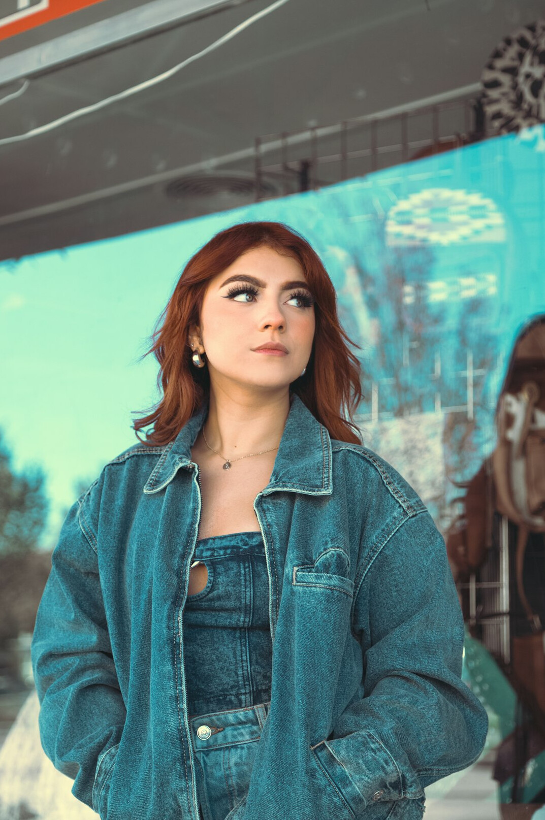 Portrait of a woman in her late twenties with red hair and a denim jacket