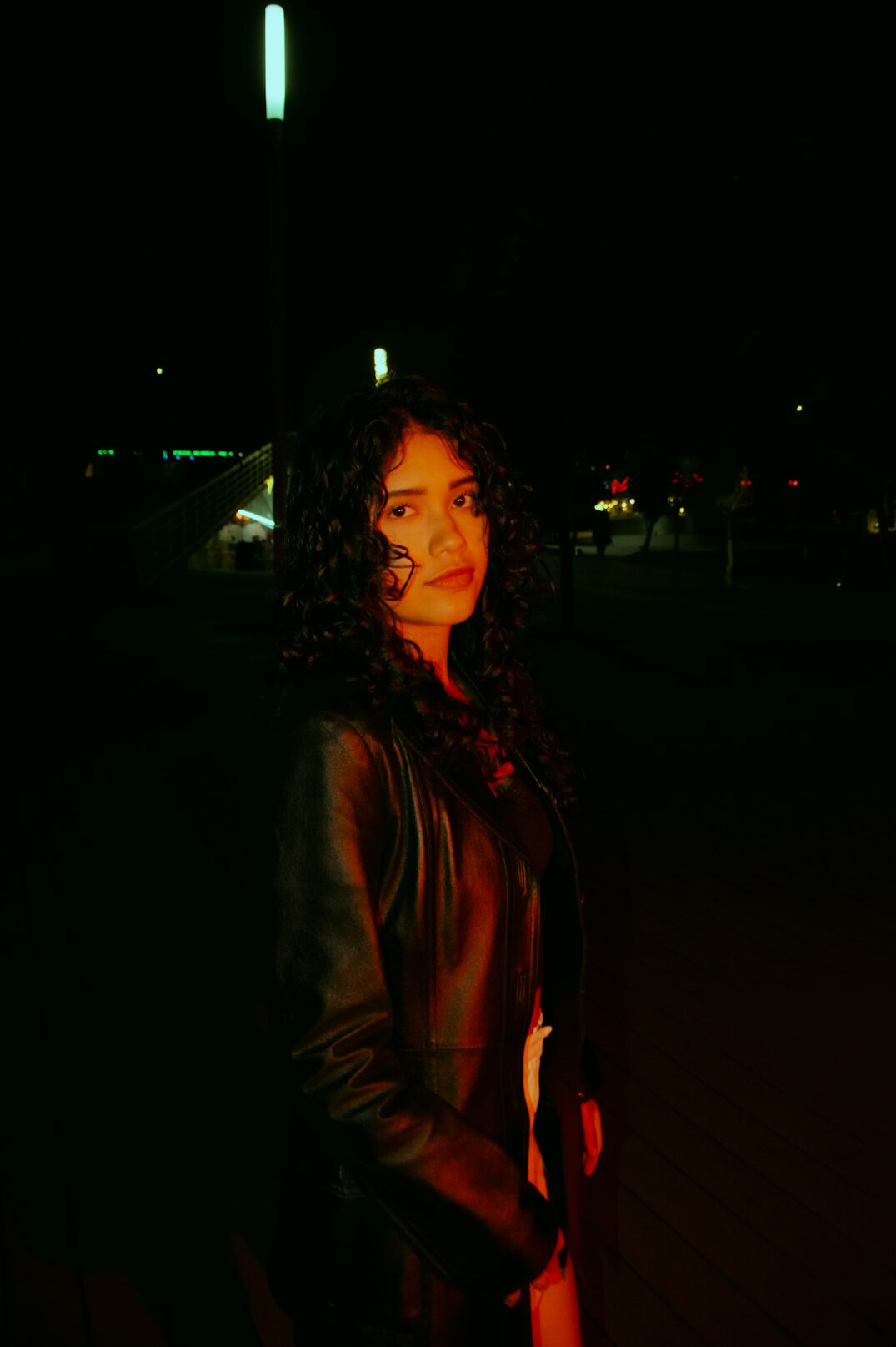 Portrait of a woman in her thirties with dark curly hair wearing a blazer